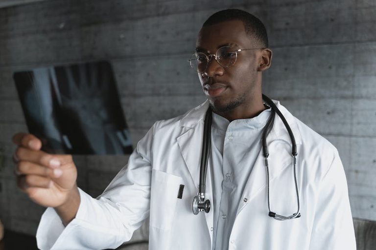 professional-doctor-with-eyeglasses-reviewing-an-x-ray-indoo